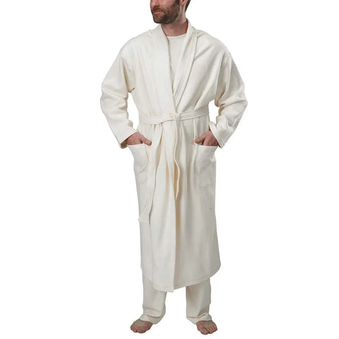 A person wearing the Spiritex Mid-Length Fleece Robe, in cream organic cotton with a belt and two front pockets, stands barefoot against a plain white background.