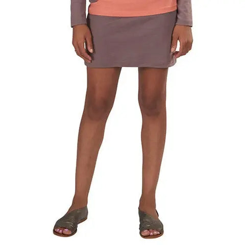 A person stands with hands at their sides, wearing the Andy Skirt by Spiritex | Sustainable Apparel in mauve, paired with a peach top and gray open-toe sandals. The eco-conscious look is shown cropped from the shoulders down.