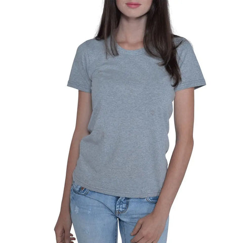 A woman with long brown hair wears the Spiritex Short Sleeve Favorite Crewneck Tee (W) in plain grey and light blue jeans, standing against a white background.