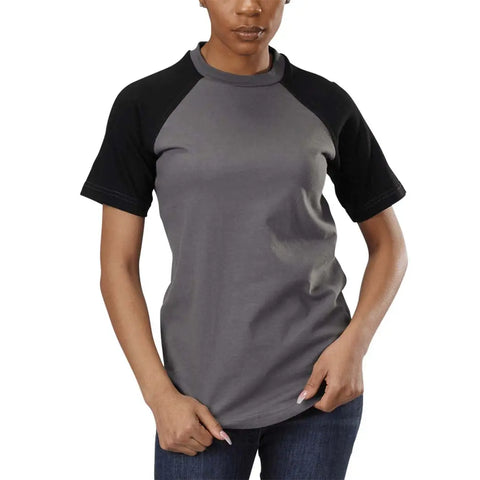 A woman stands against a white background, wearing the Spiritex | Sustainable Apparel Short Sleeve Baseball Raglan Tee—made from 100% organic cotton in grey with black raglan sleeves—and blue jeans, one hand resting on her hip.