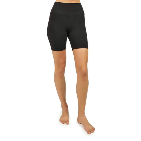 A person stands barefoot, shown waist down against a white background, wearing Spiritex | Sustainable Apparels high-waisted, black Yoga Shorts—form-fitting bike shorts that reach mid-thigh.