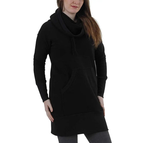 A woman wears the RAD Sweatshirt Dress by Spiritex | Sustainable Apparel—a long-sleeved black organic cotton dress with a cowl neck and large front pocket. She stands with one hand on her hip, the other on the pocket, her face partially visible.