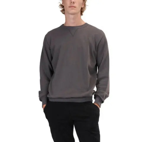 A person wears the Spiritex | Sustainable Apparel V-Inset Crewneck Sweatshirt in plain dark gray with black pants, standing with hands in pockets against a white background.