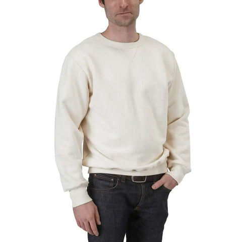 A man wears the Spiritex | Sustainable Apparel V-Inset Crewneck Sweatshirt in off-white with dark jeans, standing against a white background with one hand in his pocket. His face is partially visible.