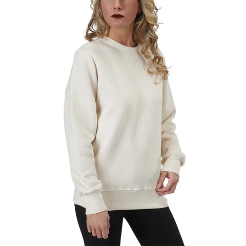 A woman with long curly hair wears the Spiritex | Sustainable Apparel V-Inset Crewneck Sweatshirt in off-white and black pants, standing against a white background.