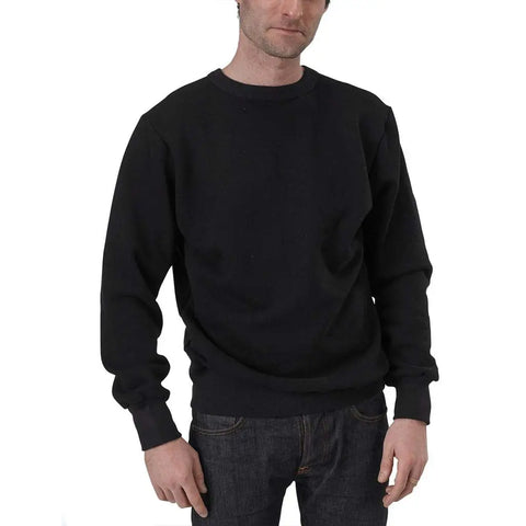 A man in a Spiritex | Sustainable Apparel V-Inset Crewneck Sweatshirt and dark jeans stands against a white background, his left hand at his side and right hand partially in his pocket.