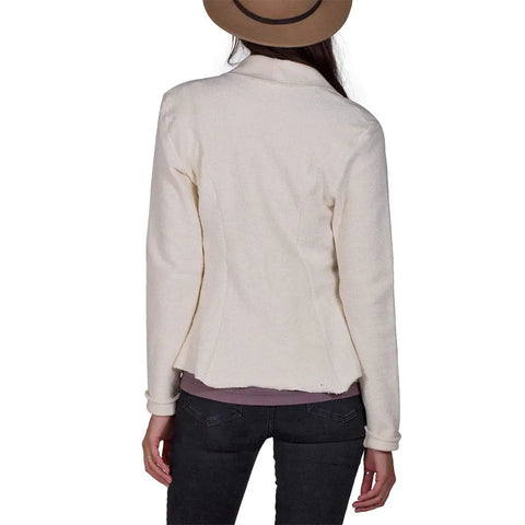 A woman is seen from the back against a white background, wearing the Spiritex | Sustainable Apparel Heavyweight Terry Tab Jacket with dark pants and a brown hat.