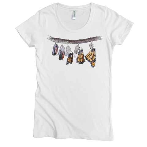 The Emerging Monarchs Tee by Spiritex | Sustainable Apparel is a women’s organic cotton shirt featuring six stages of monarch transformation illustrated on a delicate branch.