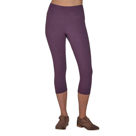 A person wearing Spiritex | Sustainable Apparel’s purple organic cotton Yoga Capri pants and brown shoes, shown from the waist down against a white background.