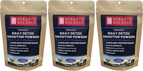 Three brown resealable bags of Ocean’s Balance Detox Smoothie Powder are shown side by side, with front labels featuring key ingredients: wild blueberries, dulse, barley grass juice, and spirulina.