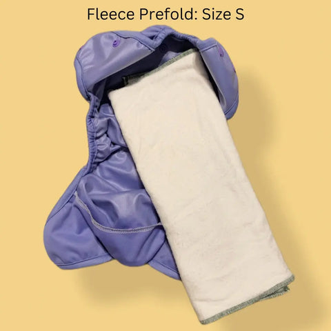 A Geffenbaby Cloth Prefold Diaper in size S, made with super absorbent fleece hemp and organic cotton, is laid open with a white insert inside on a light tan background. Text at the top reads: Fleece Prefold: Size S.