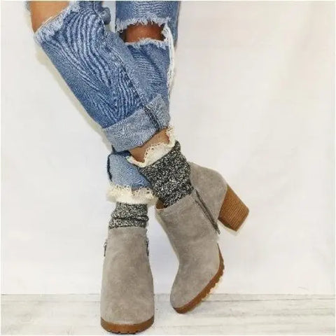 A person wears Catherine Cole’s ORGANIC Lace Boot Crew Socks in Salt N Pepper with rolled-up ripped jeans and light gray suede ankle boots, standing against a plain white background.