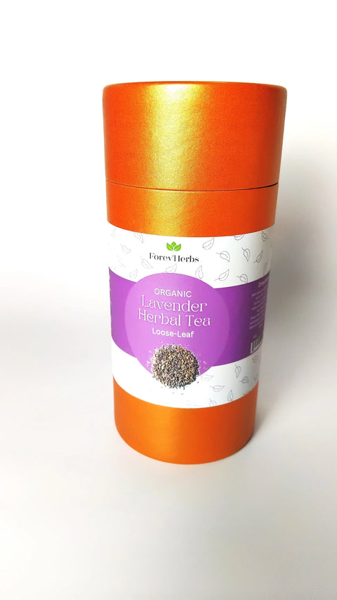 A cylindrical orange container labeled Organic Lavender Herbal Tea from Forev'Herbs, featuring a purple and white design with calming herbal tea leaves illustrated on the front.