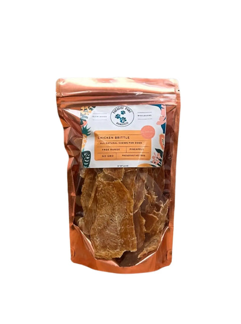 A resealable, copper-colored pouch labeled Pineapple Chicken from Dogtown Bakery contains organic chicken treats for dogs with digestive sensitivities, with branding and product details displayed against a white background.