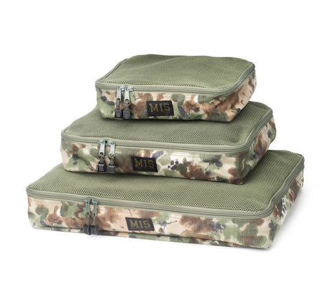 The MIS Organizer Set - Covert Woodland includes three zippered rectangular packing cubes in green and camouflage Cordura nylon, stacked by size. Each USA-made travel organizer has a mesh top and MIS label on the front.