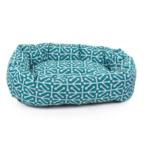 The Majestic Pet Aruba Bagel Dog Bed is a rectangular teal bed with raised sides and a white geometric pattern, shown on a white background. Its machine washable.