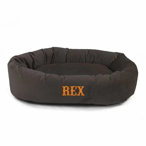 The Majestic Pet Velvet Bagel Dog Bed - Personalized features dark brown velvet, padded sides, REX in orange on the front, and offers spine support. Soft, comfy, machine washable—great for dogs or cats.