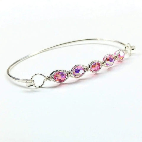 The Alexa Martha Designs Larger Oval Shaped Swarovski Crystal Bar Bangle Bracelet features five faceted pink and purple beads in wire loops and a heart detail, shown on a white background.