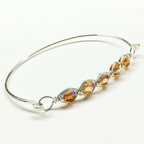 The Larger Oval Shaped Swarovski Crystal Bar Bangle Bracelet by Alexa Martha Designs features oval Swarovski crystals arranged in a row at the center of this elegant wire-wrapped sterling silver bracelet.