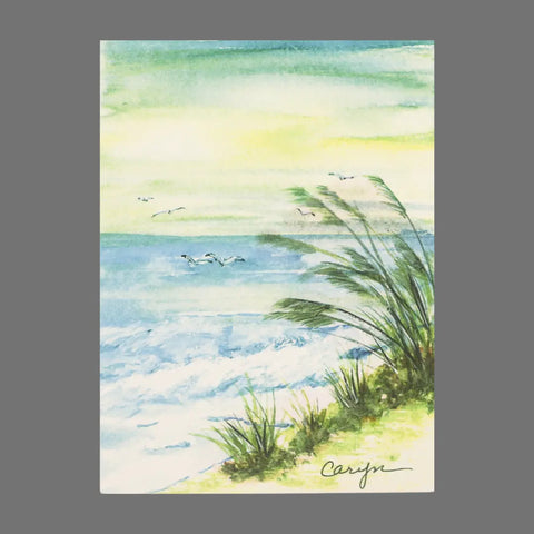This pack of 4 JuLu Cards features watercolor beach scenes with green grasses, gentle waves, a blue-green sea, and soaring seagulls. Each card is signed “Cariyn” and perfect for greeting cards or a card pack. Product code: 20040.