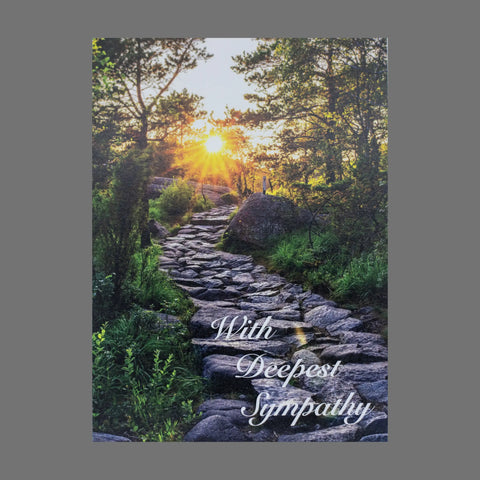 The JuLu Cards Pack of 4 With Deepest Sympathy cards (20060) features a stone path in a lush forest with sunlight streaming through trees and the sentiment in graceful white script at the bottom right.