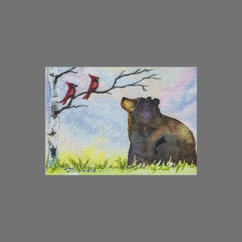 Pack of 8 “Bear With Two Cardinals” greeting cards by JuLu Cards, featuring a bear on grass looking at two red cardinals in a tree against a pastel sky. Each 3.5 x 5 card comes with a matching envelope.