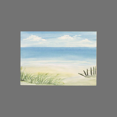 JuLu Cards Pack of 8 features a watercolor beach scene with sea, sand, dune grass, and a rustic fence under a blue sky—ideal for greeting or note cards. Design: Beach Scene With Fence and Grass (10030), shown on a plain gray background.