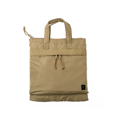 The MIS Padded F Helmet Bag S in Coyote Tan is a beige packcloth nylon tote with short handles, a front drawstring closure, padded main compartment, and a small black logo label at the bottom corner, shown on a white background.