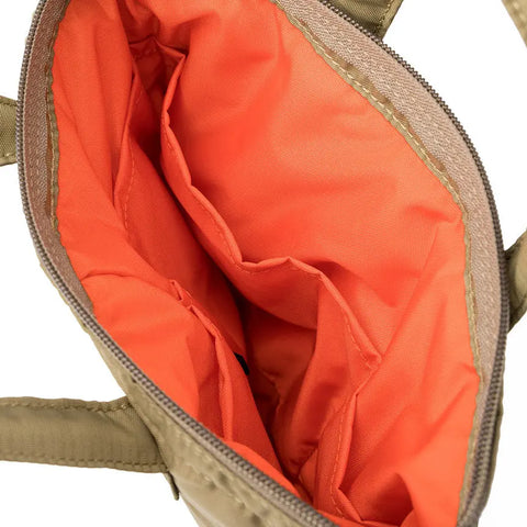 Top-down view of MIS Padded F Helmet Bag S in Coyote Tan, made in USA, showing its orange interior with multiple inner pockets and a padded main compartment through the partially unzipped zipper for organized storage.