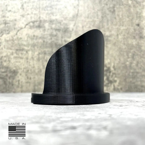 The Chatelet Manufacturing Paint Can Pourer for quart-sized cans, in black with a smooth, curved design, sits on a light textured surface. A Made in U.S.A. label with an American flag is shown; the background is gray and rough.