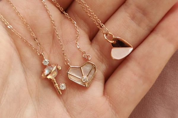 Gold necklaces with pendants held in a hand
