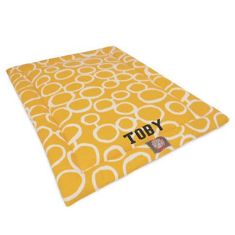 The Majestic Pet Fusion Crate Mat - Personalized features a yellow base with white circles, TOBY printed in black, a small red-tag accent, premium polyester fill, and is machine washable—perfect as both a cozy pet bed and crate mat.