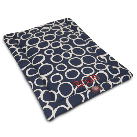 The Majestic Pet Fusion Crate Mat - Personalized features a navy blue and white circular pattern, red Rosie embroidery, premium polyester batting, and is machine washable for easy care.