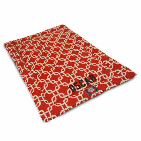 The Majestic Pet Links Crate Mat - Personalized features a red rectangular design with a white interlocking chain pattern, OSCARs name, and an emblem. Made from washable, durable polyester for lasting comfort.