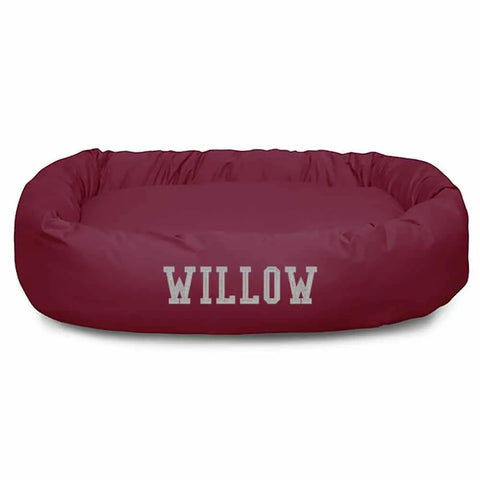 The Majestic Pet Poly/Cotton Bagel Bed - Personalized comes in maroon with raised sides for spine support and WILLOW printed in large white letters. It’s machine washable for easy cleaning.