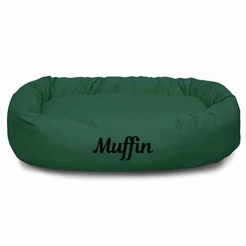 A green, oval Majestic Pet Poly/Cotton Bagel Bed - Personalized, featuring the name Muffin printed in black on the front.