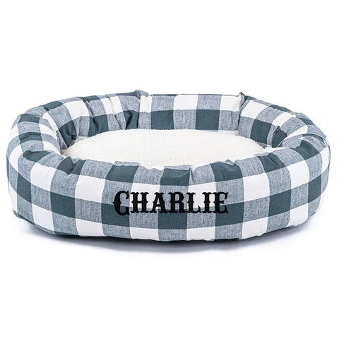 The Majestic Pet Anderson Check Sherpa Bagel Bed - Personalized features a black and white buffalo check pattern, CHARLIE embroidered on the front, and a soft white cushioned center for extra spine support.