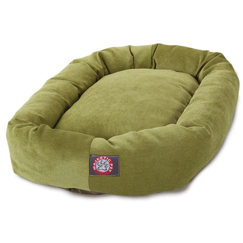 The Majestic Pet Villa Bagel Dog Bed - Personalized is a plush oval olive green bed with raised sides, a cushioned polyester micro-velvet center, and a front patch featuring a paw print logo and Majestic Pet.