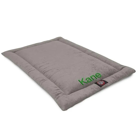 The Villa Crate Mat - Personalized by Majestic Pet is a gray rectangular polyester dog bed with Kane embroidered in green, a plush texture, machine washable, and features a small logo tag—ideal as a cozy crate mat.