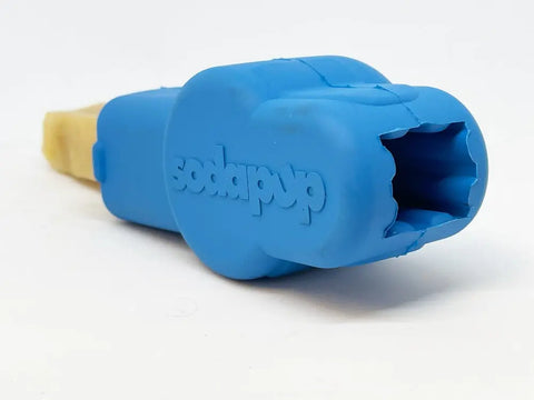 A blue Petz Yak Chew Holder EDispenser by SodaPup, featuring a bone-shaped design and an opening at one end, is shown resting on a white background.