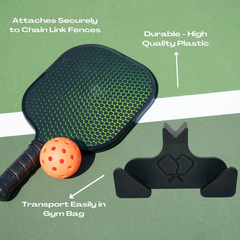 A pickleball paddle and ball rest by the Chatelet Manufacturing Pickleball Paddle Chain Link Fence Holder, which secures paddles to court fences. Made in the USA from durable plastic, it’s compact for easy gym bag transport—a must-have accessory.