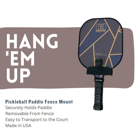 A pickleball paddle with a geometric design and black handle hangs on the Chatelet Manufacturing Pickleball Paddle Chain Link Fence Holder—securely mounts paddles, removable, compact for transport, Made in USA—with “HANG EM UP” text.