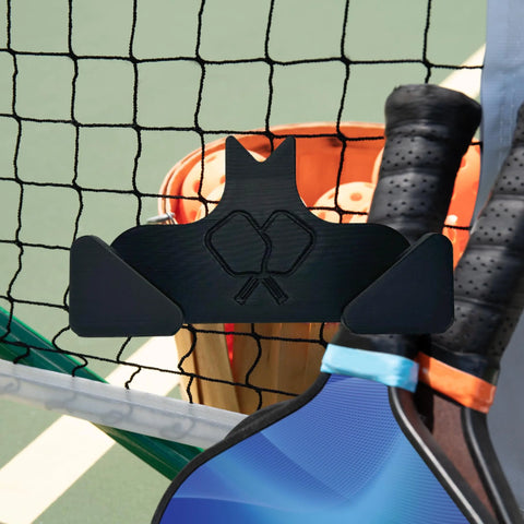 The Chatelet Manufacturing Pickleball Paddle Chain Link Fence Holder is a compact, USA-made black cat-shaped holder that mounts your paddle securely on the court fence—fun, practical, and easy to transport.