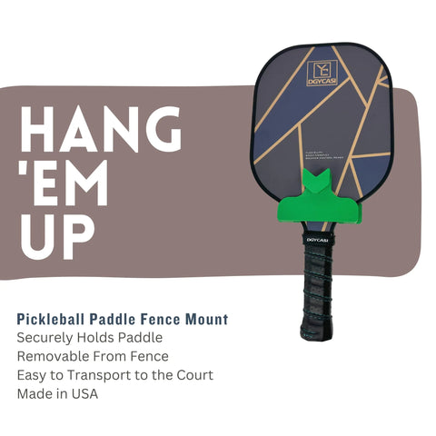 A Chatelet Manufacturing Pickleball Paddle Chain Link Fence Holder hangs on a green fence mount with HANG EM UP text. Compact, easy to transport, securely holds paddles, and is made in the USA.