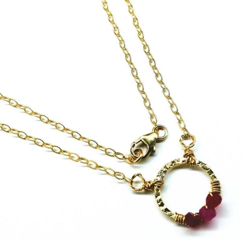 The Alexa Martha Designs Gold Filled Pink Chalcedony Open Circle Necklace, featuring a handcrafted circle pendant with pink chalcedony beads and a lobster clasp, is displayed on a white background.