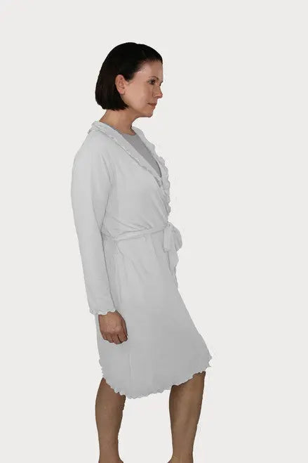 A woman with short dark hair stands in profile against a white background, wearing the Goodnighties Lettuce-Edge Robe in light gray, made in the USA, tied at the waist over a shirt.