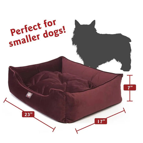 The Majestic Pet Velvet Contemporary Lounge Bed (23 x 17 x 7) in maroon is perfect for smaller dogs! Features a silhouette of a small dog for size reference.