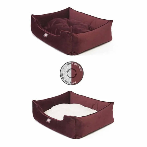 The Majestic Pet Velvet Contemporary Lounge Bed features high sides, a reversible maroon-and-white cushion, and a machine washable design. An icon highlights its reversible feature—a stylish, easy-care choice for your pet.