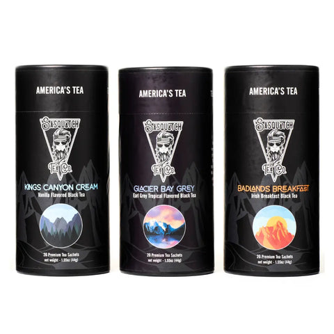 The Black Tea Bundle from Sasquatch Tea Co features three cylindrical canisters—Kings Canyon Cream, Glacier Bay Grey (Earl Grey), and Badlands Breakfast (Irish Breakfast)—each with vibrant mountain artwork.