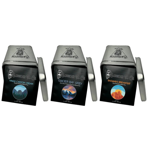Sasquatch Tea Co’s Black Tea Bundle includes Kings Canyon Cream, Glacier Bay Grey Earl Grey, and Badlands Breakfast Irish Breakfast black teas in metal tins featuring mountain-themed artwork.